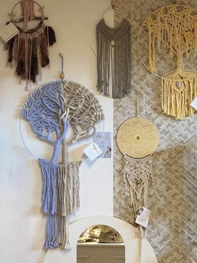 Le mur de créations Lyraë : arbres de vie et tentures en macramé, attrape-rêves et mandala doré